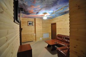ein Wohnzimmer mit einem Ledersofa und einem Tisch in der Unterkunft Voskhod Hotel in Kiew