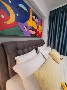 1 dormitorio con 1 cama y una pintura en la pared en Crys Luxury apartment by the Sea , first line en Mamaia