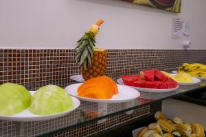 a bunch of plates of fruit on a counter at Gv Park Hotel in Governador Valadares