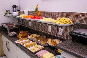 a buffet with many different types of food on a counter at Gv Park Hotel in Governador Valadares +93 photos