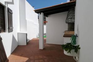 an empty hallway of a white building with a garage at Vila das Rosas in Furnas