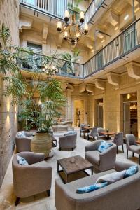 a lobby with couches and chairs and a table at 66 Saint Paul's & Spa in Valletta