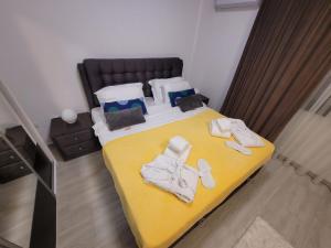 a bedroom with a yellow bed with towels on it at Suite pe plaja de lux in Mamaia Nord
