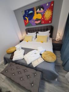 Un dormitorio con una cama con almohadas y una pintura en Crys Luxury apartment by the Sea , first line en Mamaia