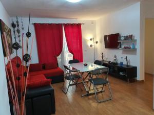 エル・メダノにあるBeach Apartmentのリビングルーム(赤いソファ、テーブル付)