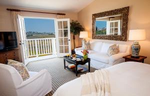 a living room with white furniture and a large window at Inn at Playa del Rey in Los Angeles