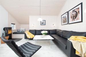 - un salon avec un canapé en cuir noir et une table dans l'établissement Resort 2 Ferienhaus Typ D 104, à Großenbrode