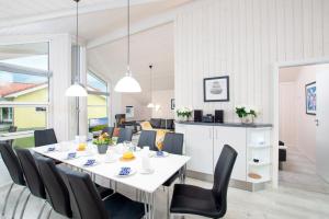 comedor con mesa blanca y sillas negras en Resort 2 Ferienhaus Typ D 122, en Großenbrode