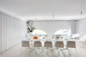 une salle à manger blanche avec une grande table et des chaises blanches dans l'établissement Hotel du Pin Nice Port, à Nice