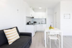 sala de estar con sofá y mesa blanca en Home2Book Sea Front Las Teresitas Beach 3, en San Andrés