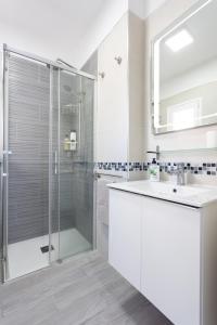 Un baño blanco con ducha y lavabo. en Home2Book Sea Front Las Teresitas Beach 3, en San Andrés