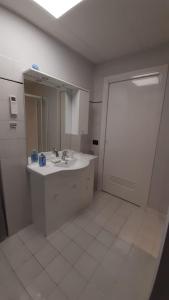 uma casa de banho com um lavatório, um espelho e uma porta em Ca' L'Archetto intero appartamento centro Cremona em Cremona