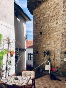 un patio con una mesa y una pared de piedra en Kosta House, en Ohrid