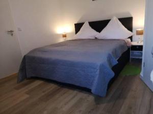 a bedroom with a large bed with white pillows at Hotel Radevormwald in Radevormwald