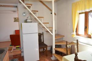 eine Küche mit einem weißen Kühlschrank und einer Treppe in der Unterkunft Vikend kuca Stefana in Šljivovica