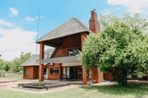a large brick house with a thatched roof at 119 Zebula in Mabula