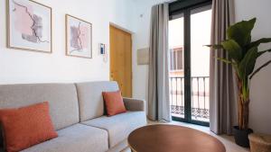 a living room with a couch and a table at Chiqui and Vicente Bright Apartment in Seville