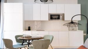 a kitchen with white cabinets and a table and chairs at Chiqui and Vicente Bright Apartment in Seville