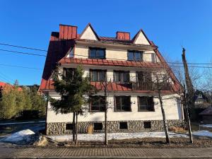 uma casa velha com um telhado vermelho em Apartament Krystynka nr 1 em Poronin