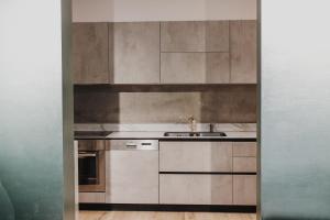 a kitchen with silver cabinets and a sink at Ivy Lalzi Bay Beach House in Durrës