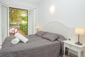 Habitación blanca con cama y ventana en Apartmento con terraza privada-c1, en Ciutadella