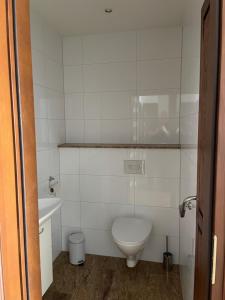 a white bathroom with a toilet and a sink at Apartament Krystynka nr 1 in Poronin