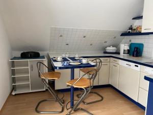 una pequeña cocina con 2 sillas y una mesa azul en Steinberg-Blick, en Herzberg am Harz