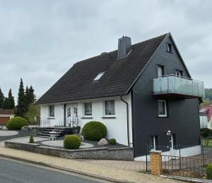 Casa en blanco y negro con balcón en Steinberg-Blick, en Herzberg am Harz