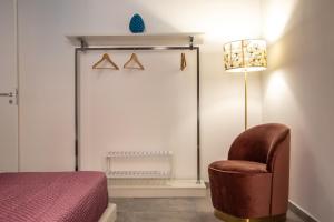 a bedroom with a chair and a lamp at Casta Diva Luxury Apartments in Palermo