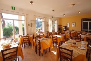 restauracja ze stołami i krzesłami z żółtą tkaniną w obiekcie Hotel Voce del Mare w mieście Capoliveri