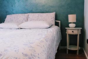 a bedroom with a bed and a table with a lamp at Ivy Lalzi Bay Beach House in Durrës