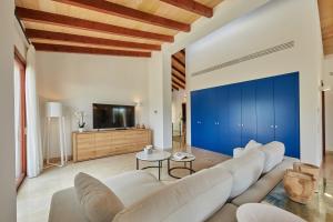 uma sala de estar com mobiliário branco e uma parede azul em Villa Jade by Cap Vermell Estate em Canyamel