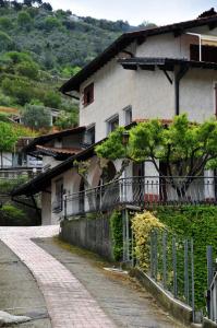 ein weißes Haus mit einem Zaun neben einer Straße in der Unterkunft Le Rose in San Biagio della Cima