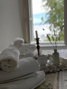 uma mesa com toalhas, uma vela e uma janela em Robinson house Leticia em Čunski