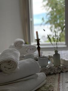 a table with towels and a candle and a window at Robinson house Leticia in Čunski