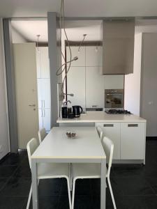 a white kitchen with a white table and chairs at Mery's House casa vacanza in Fano