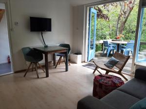 a living room with a table and chairs and a patio at Boshuisje Petten aan Zee in Petten