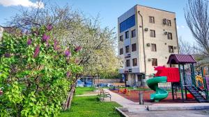 a playground with a green slide in front of a building at Hotel Alpha in Yerevan