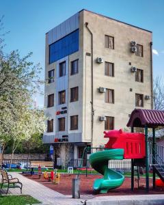 een speeltuin met een glijbaan voor een gebouw bij Hotel Alpha in Jerevan
