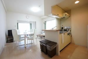 une cuisine et un salon avec une table, une cuisine et une salle à manger dans l'établissement Downtown area Spacious cozy room Susukino IK1003, à Sapporo