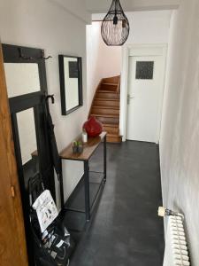 a hallway with a table and a stair case at Le Treize-Mer in Le Portel