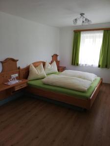een slaapkamer met een bed en een raam met groene gordijnen bij Eisl in Gmunden