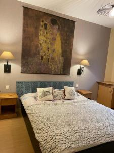 a bedroom with a bed with a painting on the wall at Résidence Grand Hôtel Appartement Standing in Aulus-les-Bains