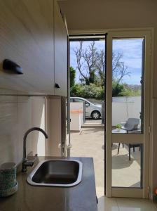 a kitchen with a sink and a view of a patio at Nonno Rocco in Castro di Lecce