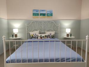 ein Schlafzimmer mit einem weißen Bett mit zwei Lampen in der Unterkunft Nonno Rocco in Castro di Lecce