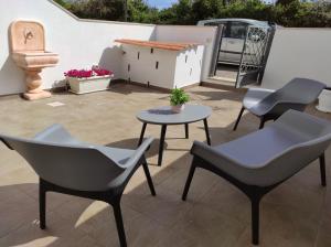 eine Terrasse mit Stühlen, einem Tisch und einem Haus in der Unterkunft Nonno Rocco in Castro di Lecce