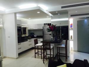 a kitchen with a table and chairs and a refrigerator at Regency Residence with Pool - Next the Beach in Herzliya