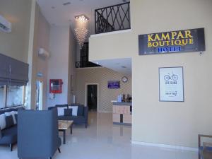 a lobby with blue chairs and a sign that reads karma boutique hotel at Kampar Boutique Hotel in Kampar