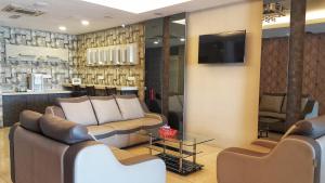 a living room with two couches and a television at Kampar Boutique Hotel (Kampar Sentral) in Kampar