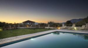 a swimming pool in a yard with a gazebo at Elaion Guesthouse in Elliniko